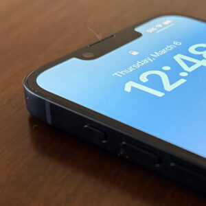 An iPhone sits on the table, displaying the time with the screen on
